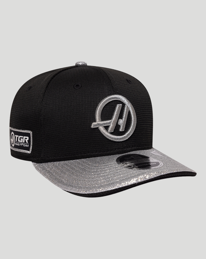 Front three quarter view of black cap with a silver circular logo on the front and glitter brim