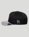 Side view of black New Era Haas cap with glitter silver brim and white New Era logo embroidered on the side panel