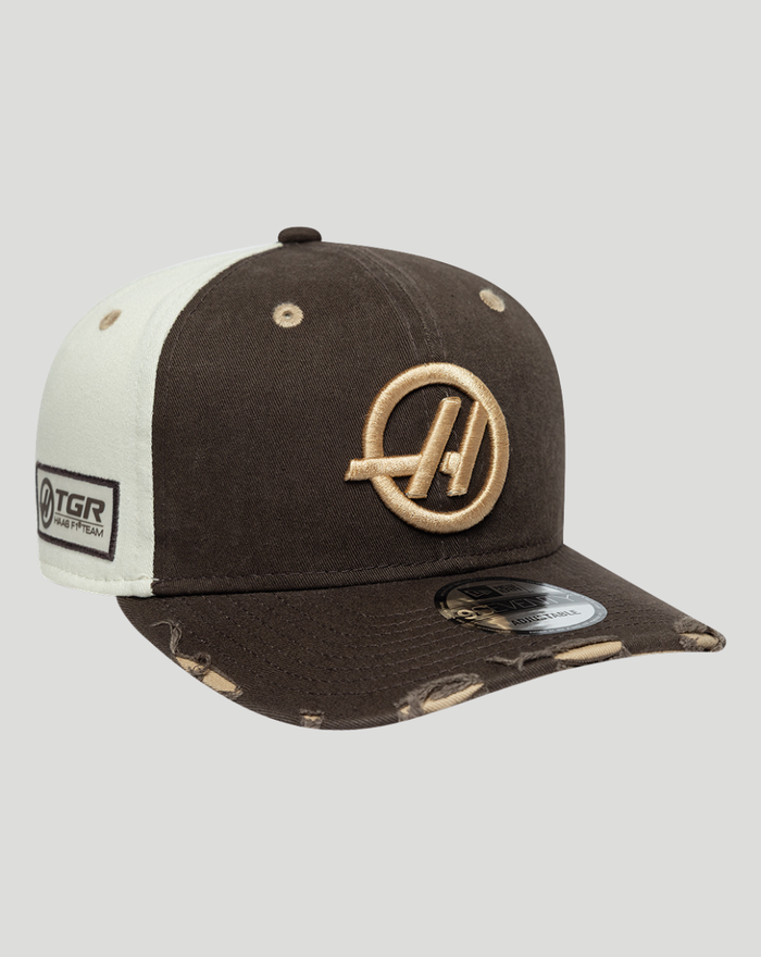 Three quarter view of a brown and cream Haas Team 9Seventy cap showing the embroidered logo on the front and a TGR patch on the side.