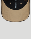 Close up of tan curved brim and black crown with 9SEVENTY label along the interior seam.