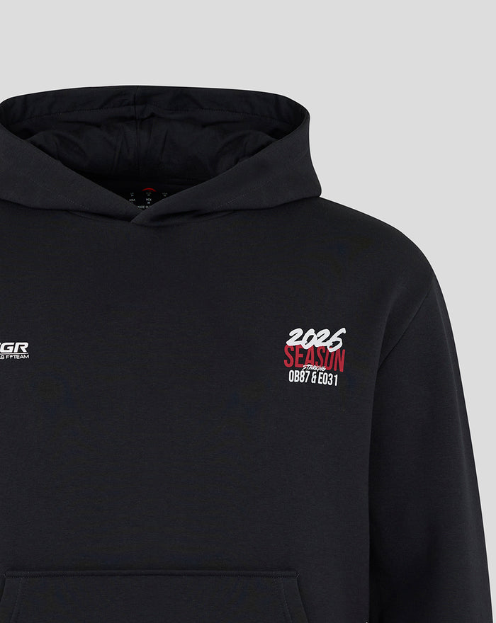 Black Haas F1 World Tour hoodie with 2025 season graphic on chest and TGR Haas Team logo on the other chest, hood with drawstrings and kangaroo pocket.