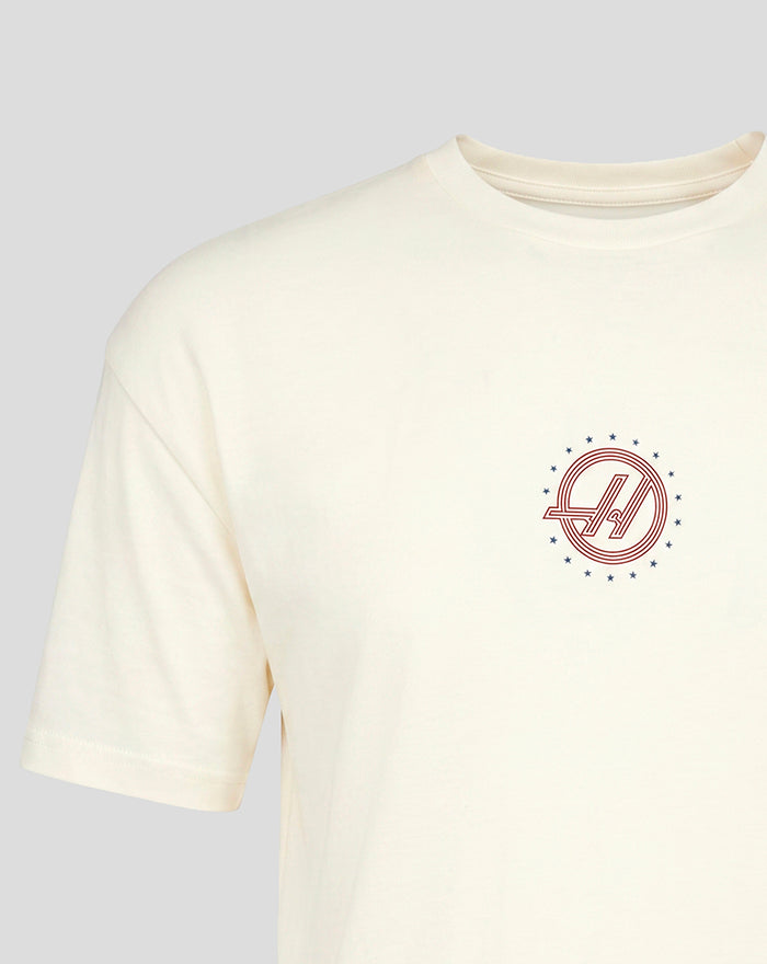 Small circular red Haas F1 Team roundel with blue stars on left chest of white T shirt.
