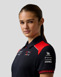 Close up of a model wearing a navy Haas Team polo with red shoulder paneling and sponsor logos on the chest and sleeve.