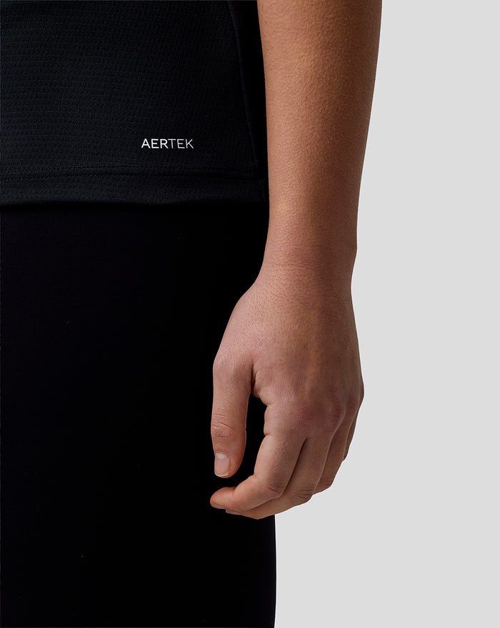 Close up of black Haas Team polo hem with white AERTEK wordmark at the front left.