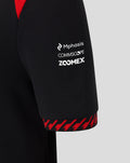 Close up of Haas Team polo sleeve in black with white sponsor logos Mphasis Commscope Zoomex and red trim.