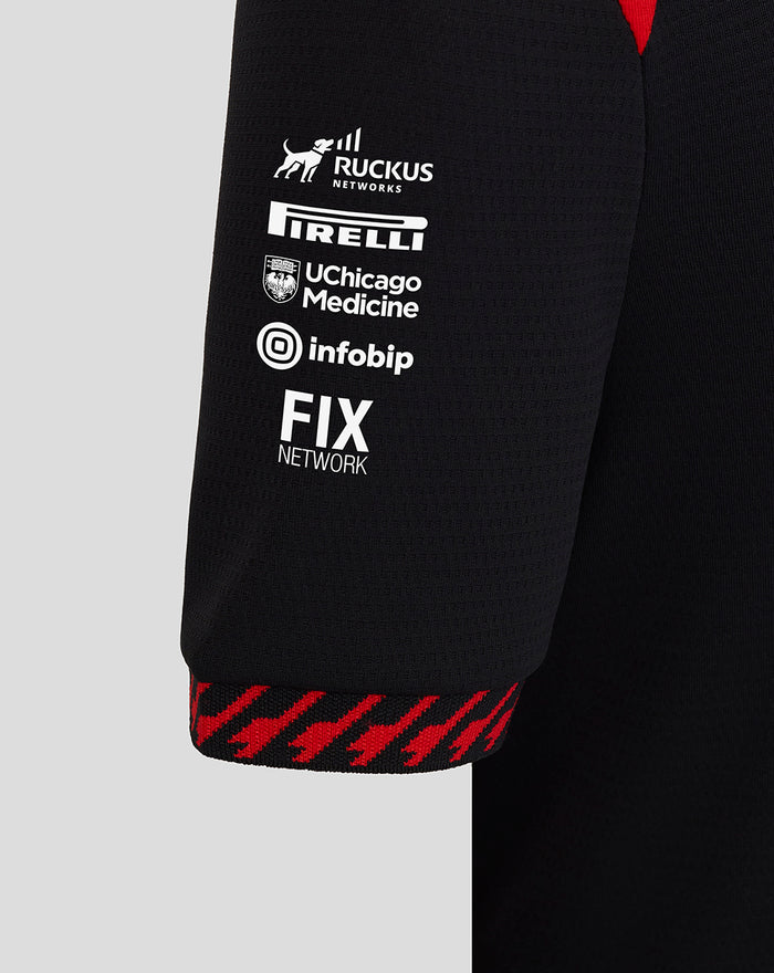 Black Haas Team polo sleeve with stacked sponsor logos Ruckus Networks Pirelli UChicago Medicine Infobip and FIX Network and red cuff edge.