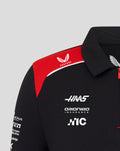 Close-up of Haas Team Junior Polo with red shoulder panel, Castore logo and Haas branding on black fabric