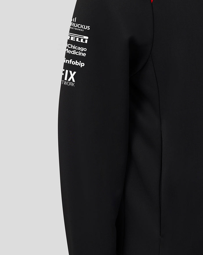 Sleeve detail showing white sponsor logos and a red shoulder panel on the hoodie.