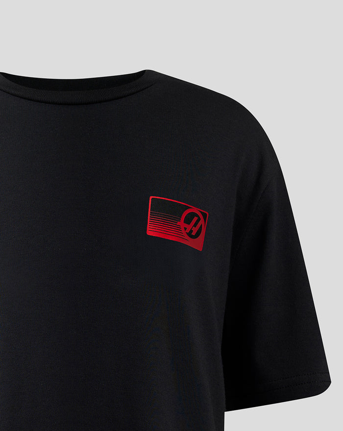 Black T shirt with a small red left chest logo and woven sponsor label at the front hem.