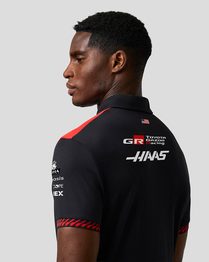 Model wearing Official Haas Team men's short sleeve polo in black with red shoulder stripe and back branding