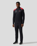 Front view of a man wearing the Haas Team Quarter Zip Midlayer with red shoulder panels and sponsor logos on the chest and sleeve.