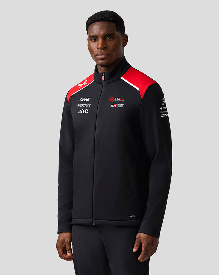 Male model wearing Official Haas Team Unisex Soft Shell Jacket with ProTek water-repellent finish and front zip