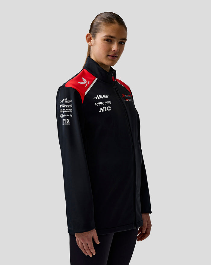 Black Haas Team Soft Shell Jacket with red shoulder panels and full front zipper worn by a model