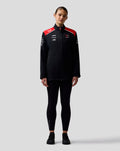 Female model wearing Official Haas Team Soft Shell Jacket in black with red shoulder panels and branding on the chest