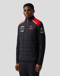 Model wearing Haas Team unisex gilet in black with red shoulder panels front zip and quilted panels
