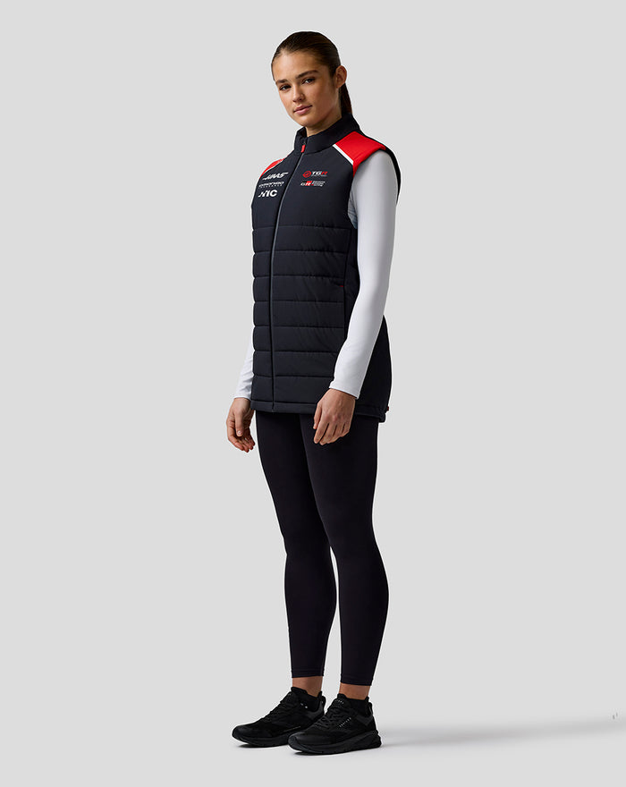 Full-body front view of a model in the Haas Team Gilet with red shoulders and black pants