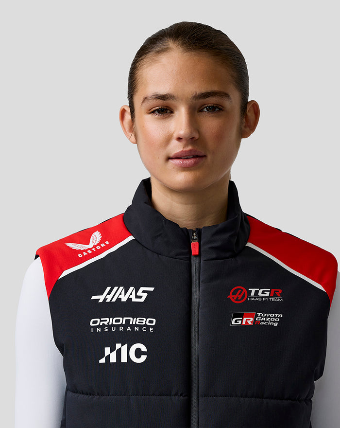 Front view of a female model wearing Official Haas Team Unisex Gilet in black with red shoulders and team branding.