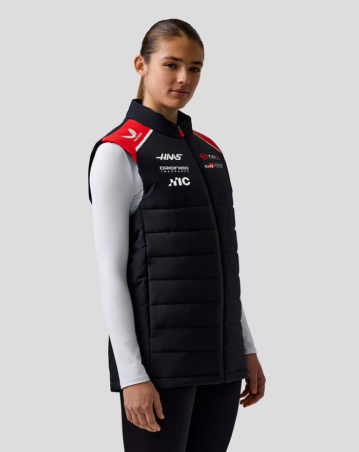 Female model wearing Official Haas Team Unisex Gilet with black body and red shoulder panels.