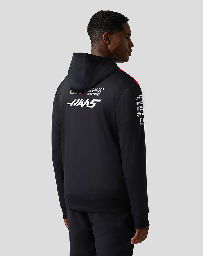 Male model seen from the back in a Haas Team pullover hoodie with large logos on the back.