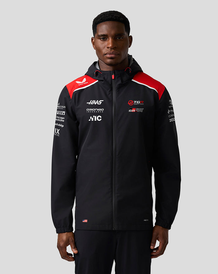 Front view of Haas Team water resistant jacket on a model, black with red shoulder panels, hood and full front zip.