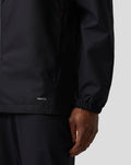 Detail of the jacket sleeve and hem showing the PROTEK branding and elastic cuff.