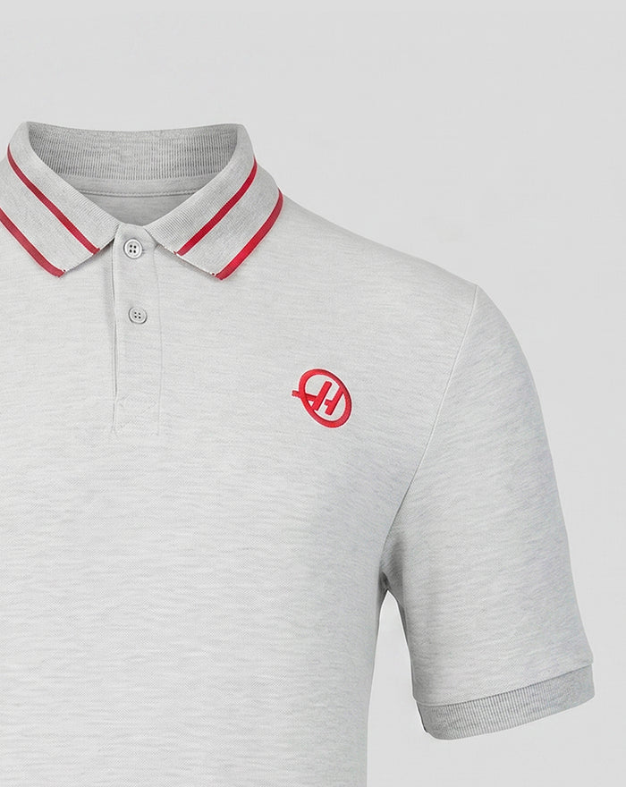 Grey Haas polo with left chest logo and upper back branding, red striped rib collar and right arm sponsor label