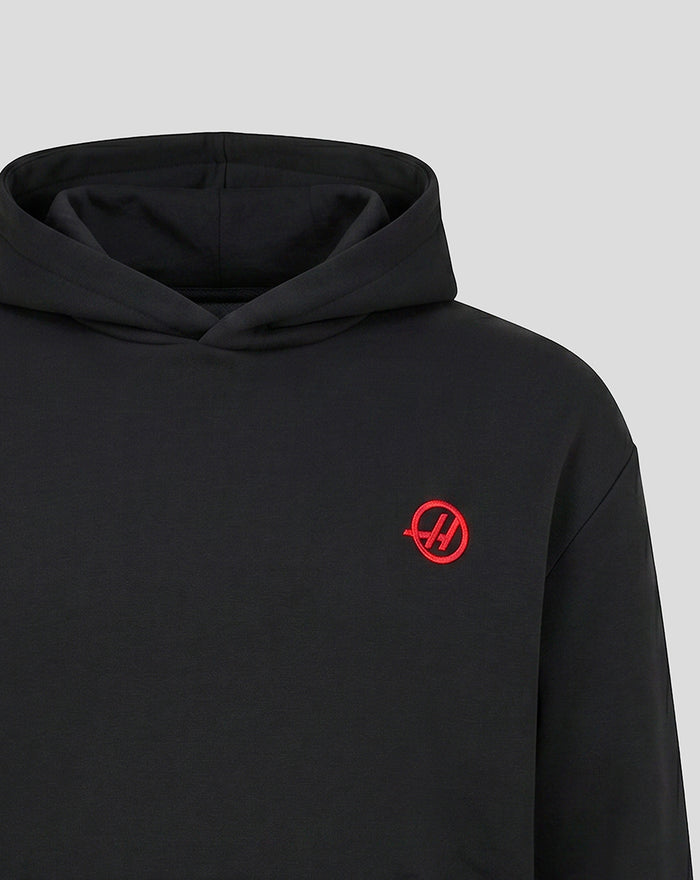 Front view of black Haas hoodie with red logo on the left chest and a visible hood.