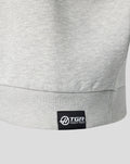 Close up of the grey heather Haas quarter zip hem with black woven TGR Haas F1 Team label at the lower left front.