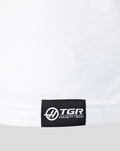 Close up of white T shirt hem with a black woven TGR Haas F1 Team logo label